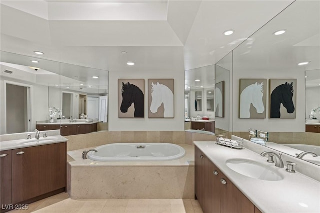 bathroom with a garden tub, two vanities, recessed lighting, and tile patterned floors