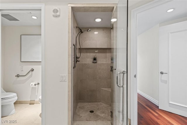 full bath featuring a shower stall, toilet, baseboards, and recessed lighting