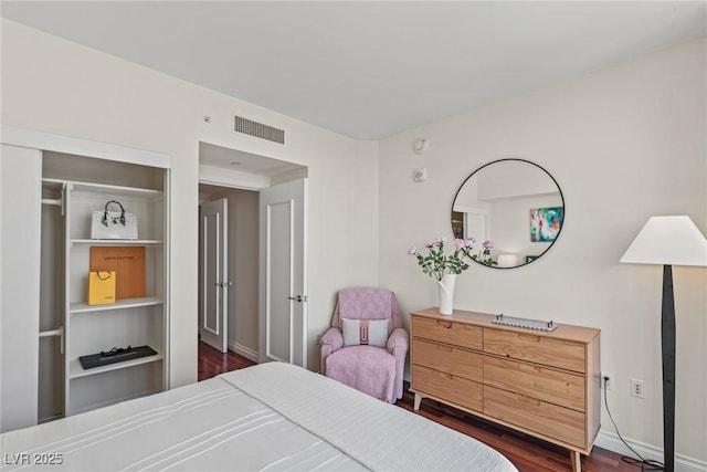 bedroom with dark wood-type flooring and baseboards
