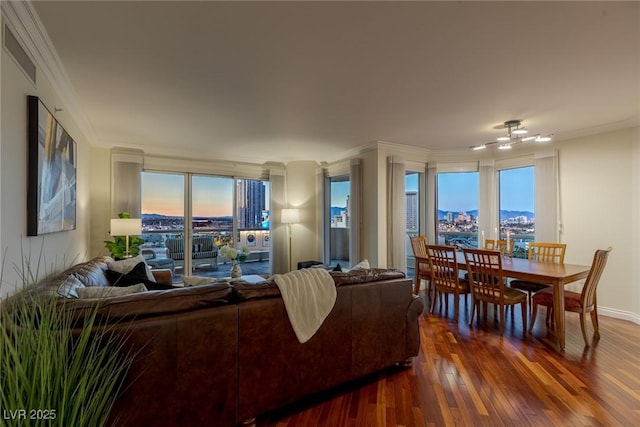 living room featuring ornamental molding, dark wood finished floors, healthy amount of natural light, baseboards, and a city view
