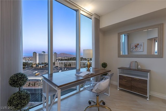 home office featuring baseboards, plenty of natural light, and a mountain view