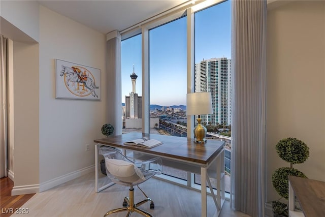 home office with a view of city, baseboards, and a wall of windows