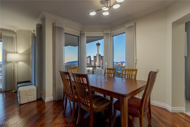dining room with a chandelier, baseboards, hardwood / wood-style floors, and ornamental molding