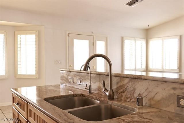 6016 Bungalow Bay St, Las Vegas, NV 89130 - kitchen featuring a sink, light stone counters, healthy amount of natural light, and light tile patterned flooring