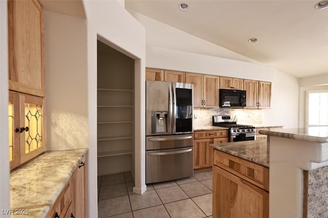 6016 Bungalow Bay St, Las Vegas, NV 89130 - kitchen featuring appliances with stainless steel finishes, decorative backsplash, light stone counters, vaulted ceiling, and light tile patterned flooring