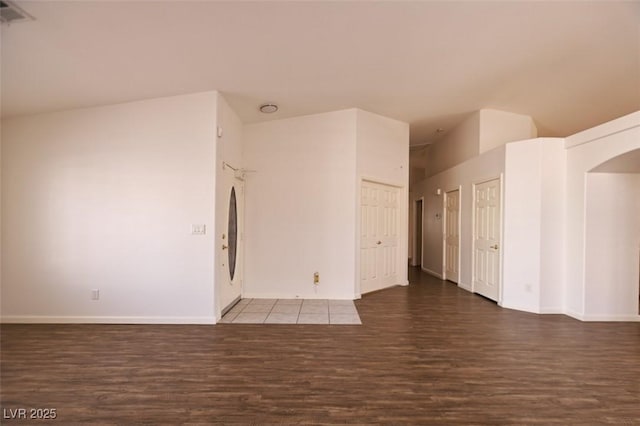 6016 Bungalow Bay St, Las Vegas, NV 89130 - empty room featuring wood finished floors, arched walkways, vaulted ceiling, and baseboards
