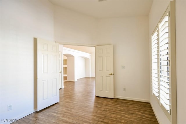 6016 Bungalow Bay St, Las Vegas, NV 89130 - unfurnished room featuring arched walkways, wood finished floors, and baseboards
