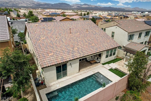 aerial perspective of suburban area featuring a mountain backdrop and a pool area