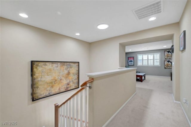 hall with an upstairs landing, light carpet, recessed lighting, and baseboards