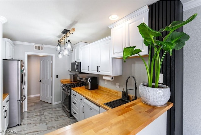 kitchen with wood counters, stainless steel appliances, a sink, light marble finish flooring, and white cabinetry