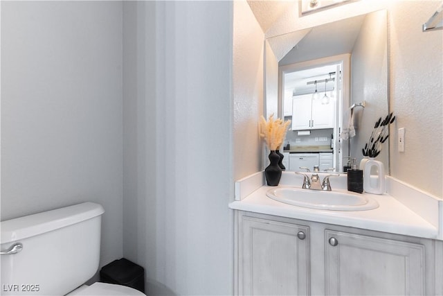bathroom featuring toilet and vanity