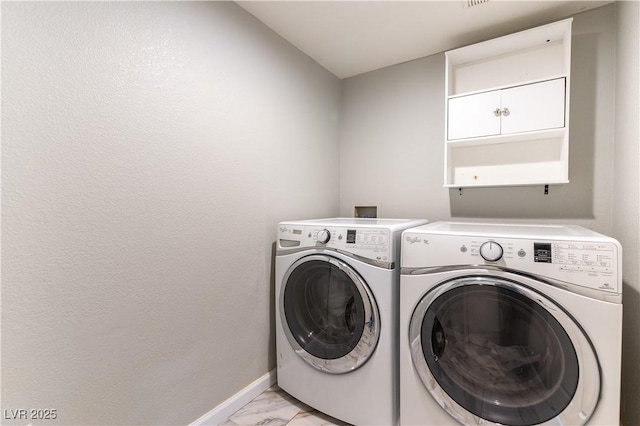 washroom with washing machine and clothes dryer, light marble finish floors, and baseboards