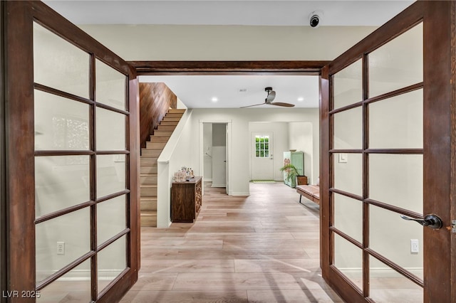 hall with light wood-style floors, recessed lighting, baseboards, and stairway