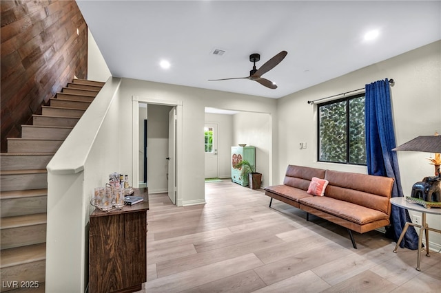 living room featuring ceiling fan, stairs, light wood-type flooring, recessed lighting, and baseboards