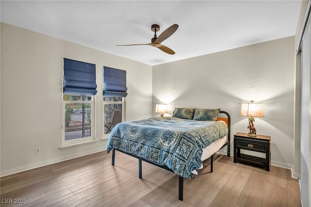 bedroom with wood finished floors, baseboards, and a ceiling fan