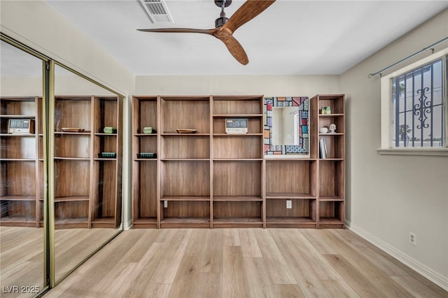 unfurnished bedroom with wood finished floors, baseboards, ceiling fan, and a closet