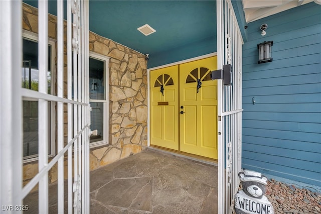 doorway to property featuring stone siding