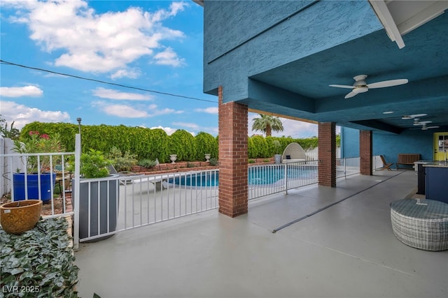 view of swimming pool with ceiling fan, fence, and a patio area