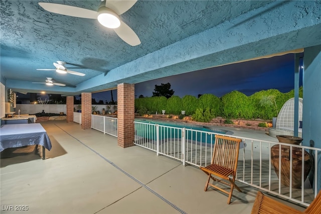view of swimming pool featuring ceiling fan and a patio area