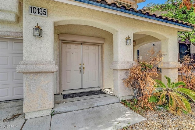 10135 Diving Duck Ave, Las Vegas, NV 89117 - doorway to property featuring stucco siding and a garage