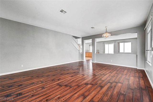 10135 Diving Duck Ave, Las Vegas, NV 89117 - unfurnished living room featuring a chandelier, dark wood-style flooring, baseboards, and stairway