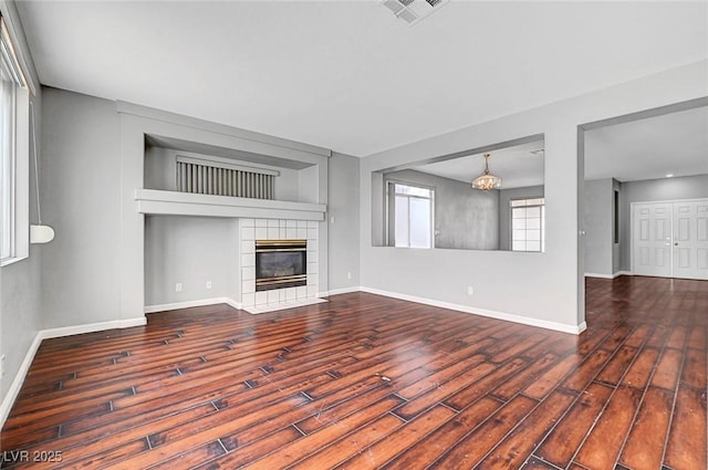 10135 Diving Duck Ave, Las Vegas, NV 89117 - unfurnished living room featuring wood finished floors, baseboards, a fireplace, and a chandelier