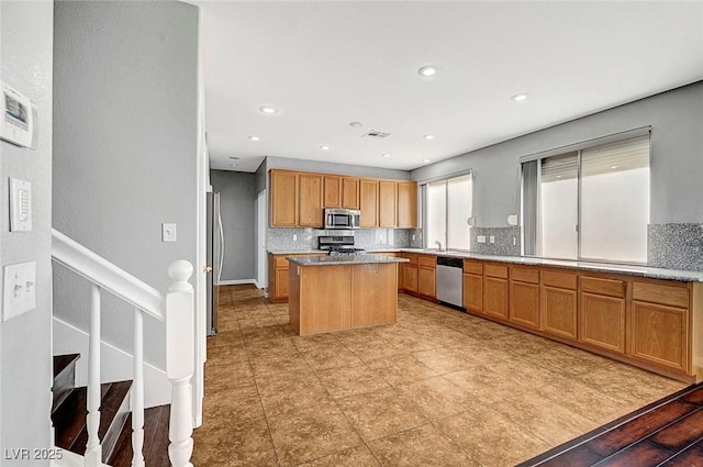 10135 Diving Duck Ave, Las Vegas, NV 89117 - kitchen with appliances with stainless steel finishes, decorative backsplash, a kitchen island, light countertops, and recessed lighting