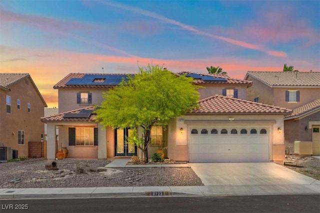 8723 Melissa Meadows St, Las Vegas, NV 89131 - mediterranean / spanish-style house featuring solar panels, an attached garage, concrete driveway, and stucco siding