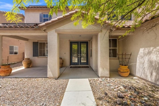 8723 Melissa Meadows St, Las Vegas, NV 89131 - view of exterior entry featuring french doors, stucco siding, and a tiled roof