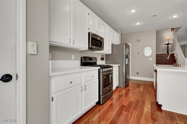 10046 Floragold Ct, Las Vegas, NV 89147 - kitchen featuring stainless steel appliances, a sink, white cabinetry, light countertops, and recessed lighting