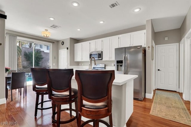 10046 Floragold Ct, Las Vegas, NV 89147 - kitchen with appliances with stainless steel finishes, wood finished floors, light countertops, white cabinets, and recessed lighting