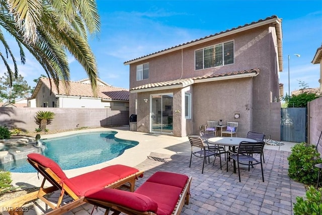 10046 Floragold Ct, Las Vegas, NV 89147 - back of property featuring stucco siding, a fenced backyard, a pool with connected hot tub, and a patio