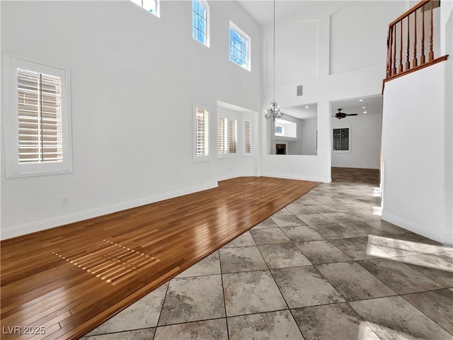 10056 Cranbrook Falls Ct, Las Vegas, NV 89148 - unfurnished living room with a chandelier, a towering ceiling, baseboards, tile patterned floors, and ceiling fan