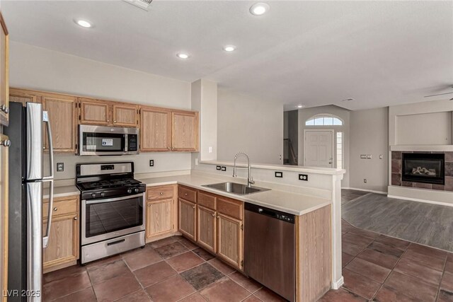 4705 Delicate Arch Ct, North Las Vegas, NV 89031 - kitchen with stainless steel appliances, a sink, open floor plan, a peninsula, and light brown cabinetry