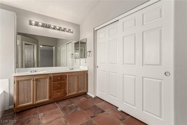 4705 Delicate Arch Ct, North Las Vegas, NV 89031 - bathroom featuring a bath, double vanity, and stone finish flooring