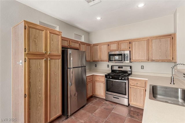 4705 Delicate Arch Ct, North Las Vegas, NV 89031 - kitchen with stainless steel appliances, a sink, light countertops, light brown cabinets, and recessed lighting
