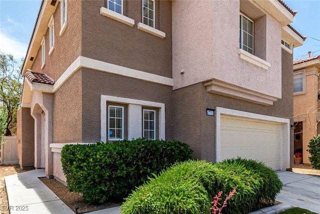 4705 Delicate Arch Ct, North Las Vegas, NV 89031 - view of front of home featuring a garage, stucco siding, a tiled roof, and concrete driveway