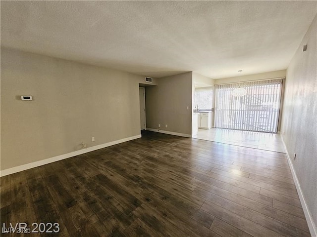 1405 Vegas Valley Dr Unit 380, Las Vegas, NV 89169 - unfurnished room featuring dark wood-type flooring, baseboards, and a textured ceiling