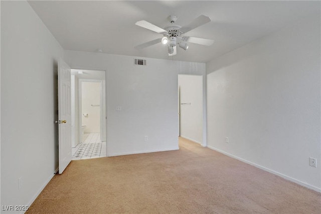 empty room featuring light colored carpet, ceiling fan, and baseboards