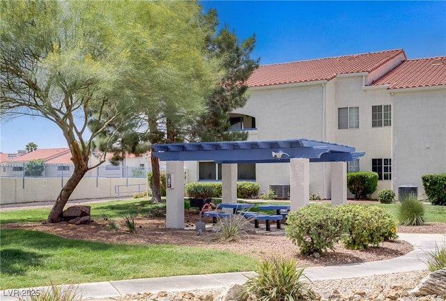 back of property with a tiled roof, stucco siding, fence, and cooling unit