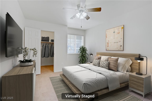 bedroom featuring light carpet, a spacious closet, a closet, baseboards, and ceiling fan