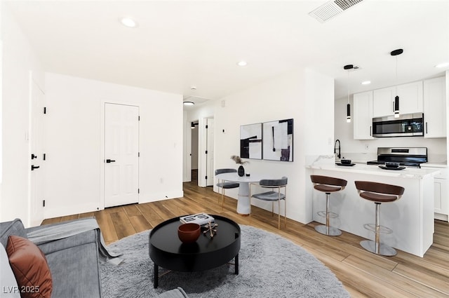 living room featuring light wood-style flooring and recessed lighting