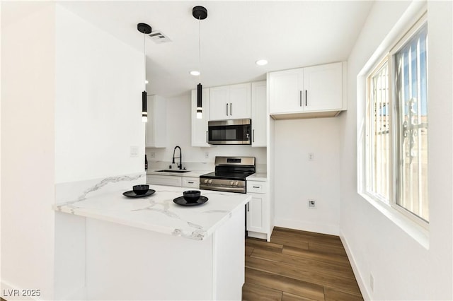kitchen featuring stainless steel appliances, a sink, dark wood-style flooring, white cabinets, and recessed lighting