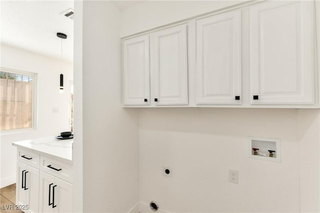 washroom featuring cabinet space, hookup for a washing machine, electric dryer hookup, and baseboards