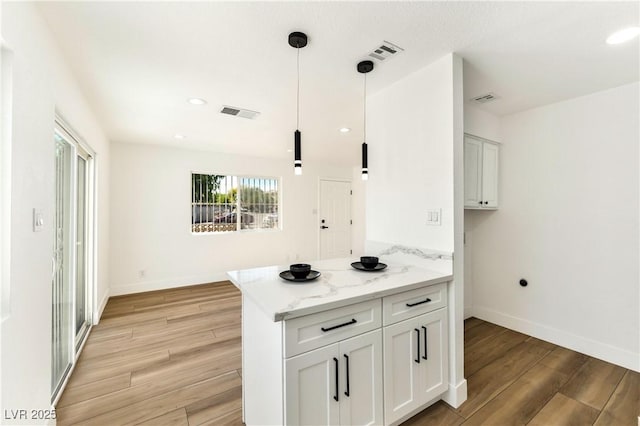 kitchen featuring light wood-style flooring, baseboards, white cabinetry, and recessed lighting