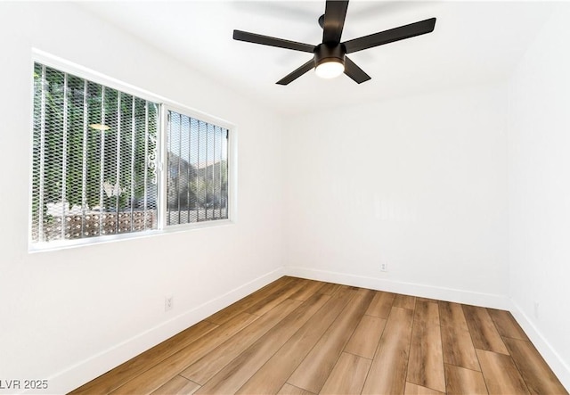 empty room featuring baseboards, wood finished floors, and ceiling fan