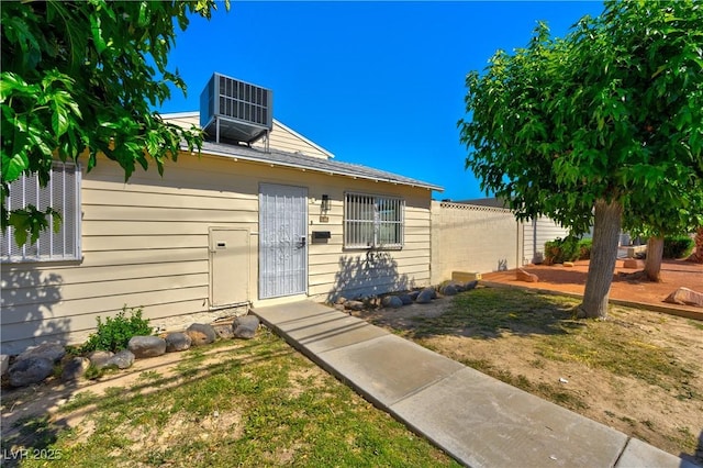 view of front of house featuring central air condition unit and fence