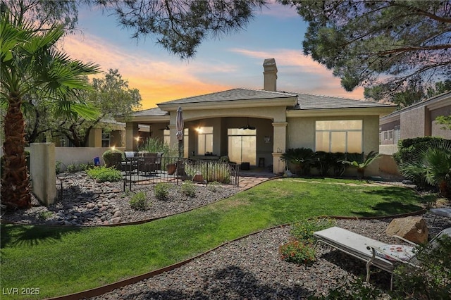 304 Cambrian Ridge Ct, Las Vegas, NV 89144 - back of house at dusk with a chimney, stucco siding, and a patio