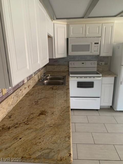 kitchen featuring white appliances, backsplash, a sink, and white cabinetry
