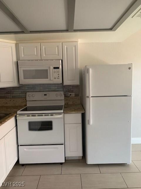kitchen with white appliances, light tile patterned floors, backsplash, and white cabinetry